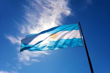 mast with the flag of argentina against the blue sky on a windy day